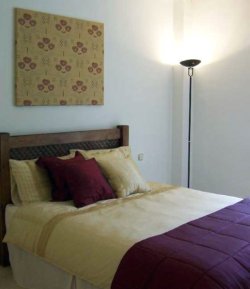 Red and gold bedding with fabric wall panel